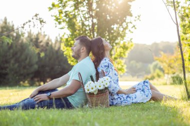 Cheerful young loving couple is relaxing in park