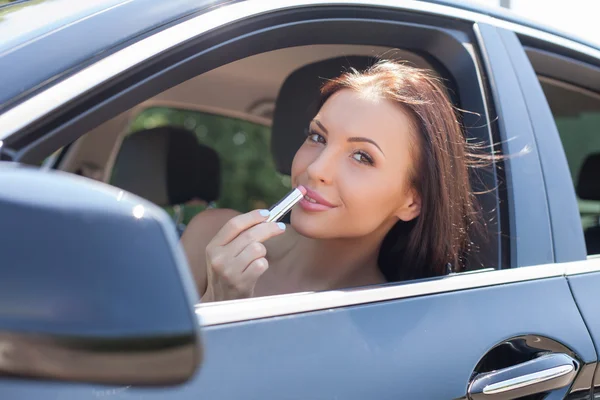 Attractive young woman is preparing for date in car — Stock Photo, Image