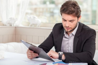 Cheerful young businessman is preparing for meeting