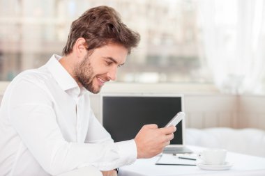 Cheerful young man is working on his project