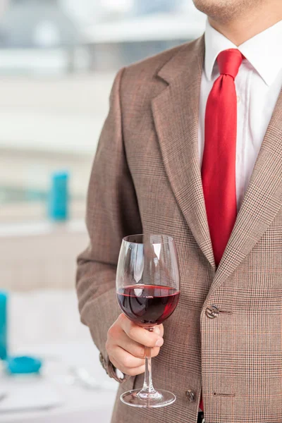 Un jeune homme d'affaires prospère boit de l'alcool lors d'une réunion — Photo