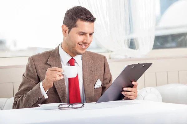 Handsome young man is reading some documents — Stok fotoğraf