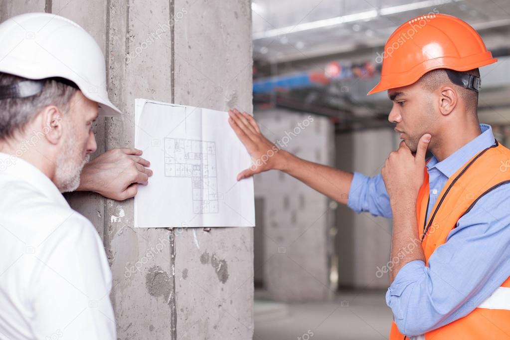 Cheerful skilled builders are solving construction problems
