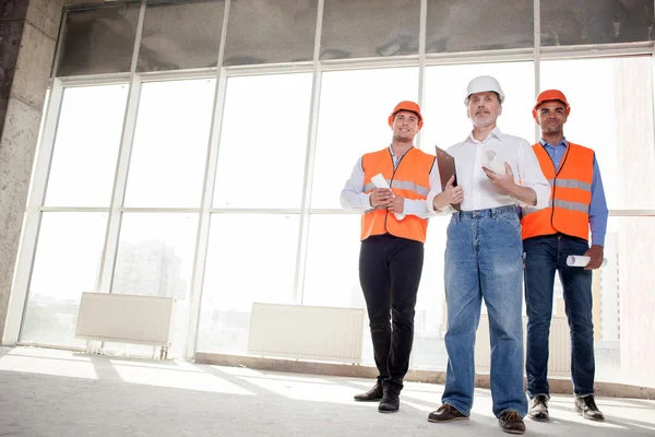 Cheerful skilled builders are meeting their client — Stock Photo, Image