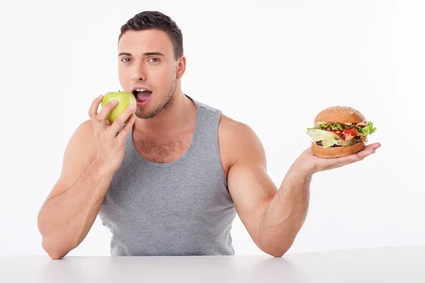 Attractive young fit guy chooses healthy food — Stock Photo, Image