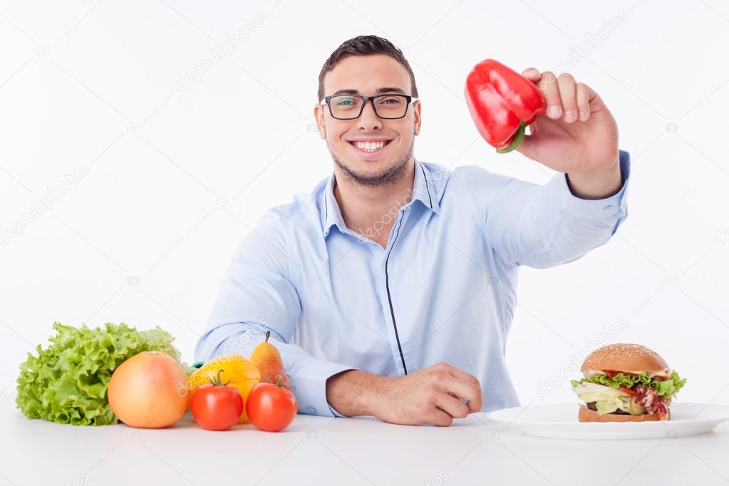 Cheerful young guy prefers to eat healthy food