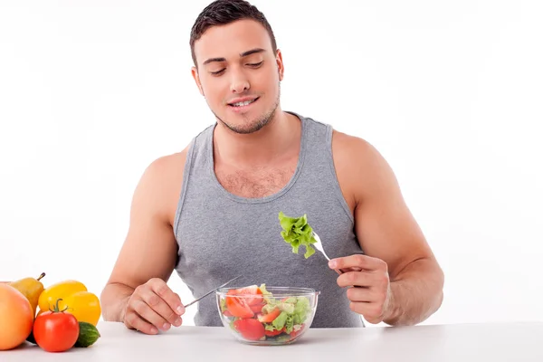 Handsome young man is eating healthy food — Stock Photo, Image