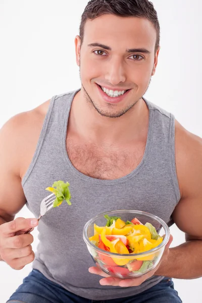 Handsome young guy is eating tasty food — Stok fotoğraf