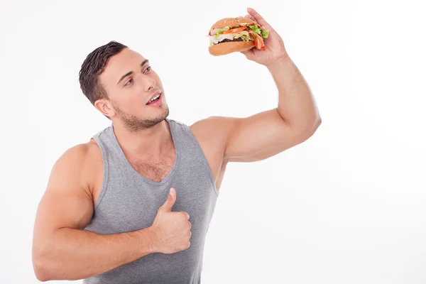 Bello giovane uomo sta mangiando cibo malsano — Foto Stock