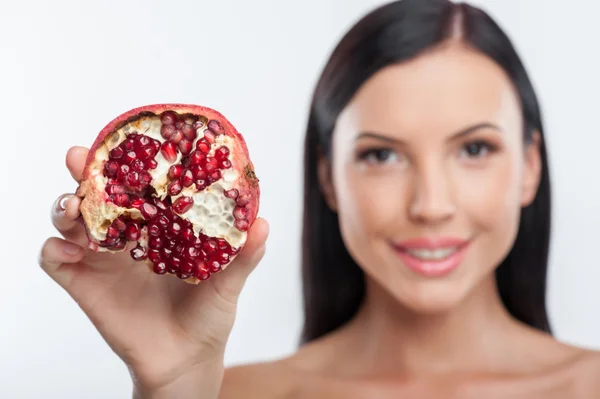 Jovem alegre está apresentando uma fruta exótica — Fotografia de Stock