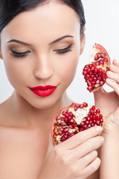 Cheerful young woman is eating healthy fruit — Stok fotoğraf