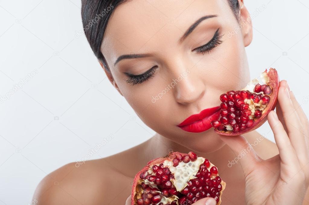 Attractive young woman is playing with healthy fruit