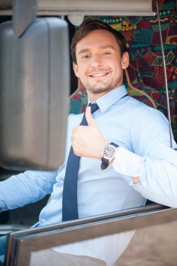 Cheerful young male driver is expressing positive emotions