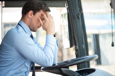 Attractive young driver has pain in his head
