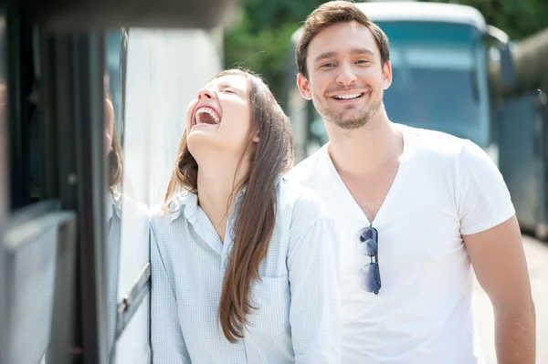 Cheerful loving couple is waiting for the bus departure — Stock Photo, Image