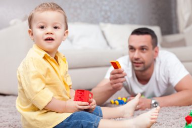 Pretty child is playing with his father