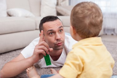 Handsome young man is teaching his little child