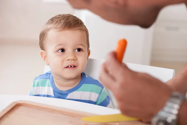 Jovem bonito está preparando comida para seu filho — Fotografia de Stock