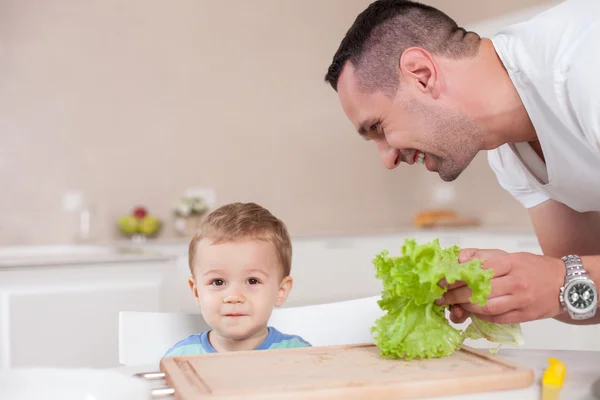 Bonito jovem está alimentando seu filho — Fotografia de Stock