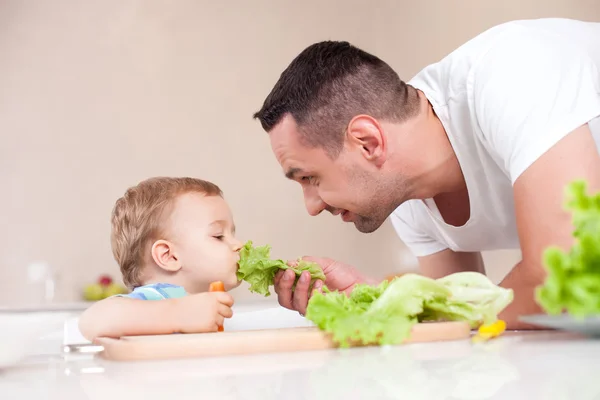 Padre guapo está dando comida saludable a su hijo —  Fotos de Stock