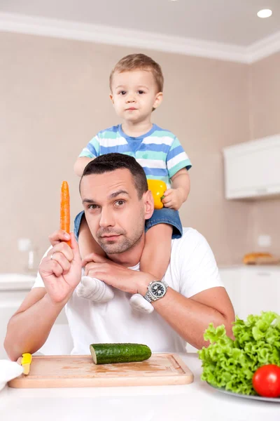 Jovem pai alegre está cozinhando para seu filho — Fotografia de Stock