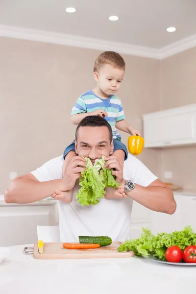 Привлекательный мужчина готовит здоровую пищу для своего ребенка — стоковое фото