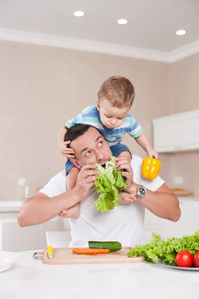 Handsome father and his child are making fun in kitchen — Stockfoto