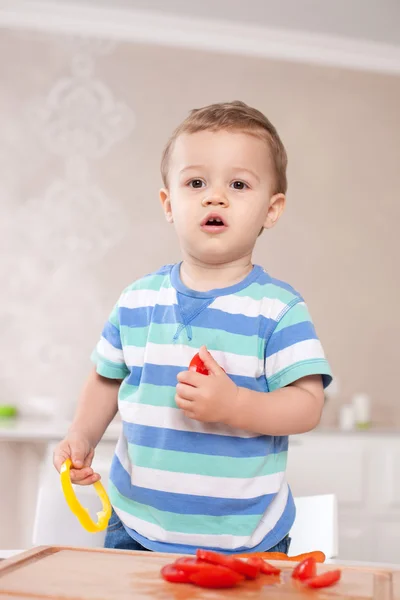 Cheerful small kid is tasting healthy food — Stock Photo, Image