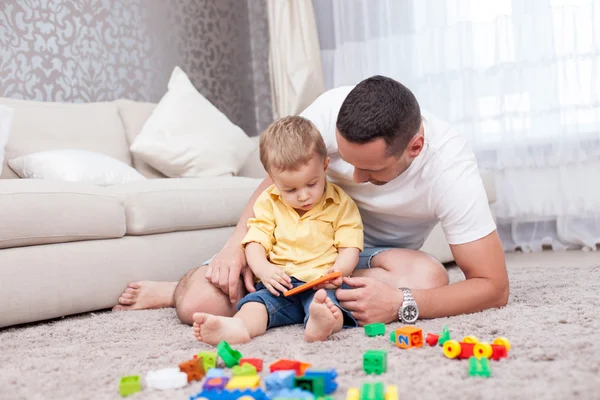 Joven alegre está jugando con su hijo — Foto de Stock