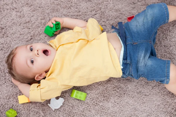 Cute small kid is making fun on flooring — Stockfoto