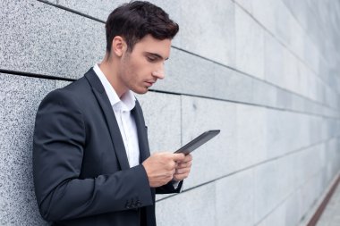 Attractive young man in suit is working with laptop