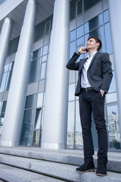 Привлекательный молодой бизнесмен общается по телефону — стоковое фото