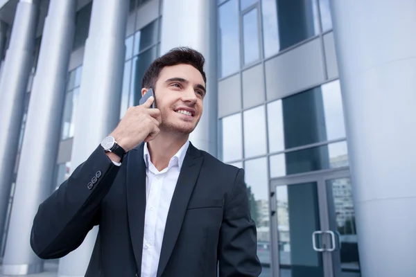 Guapo joven está utilizando el teléfono para la comunicación — Foto de Stock