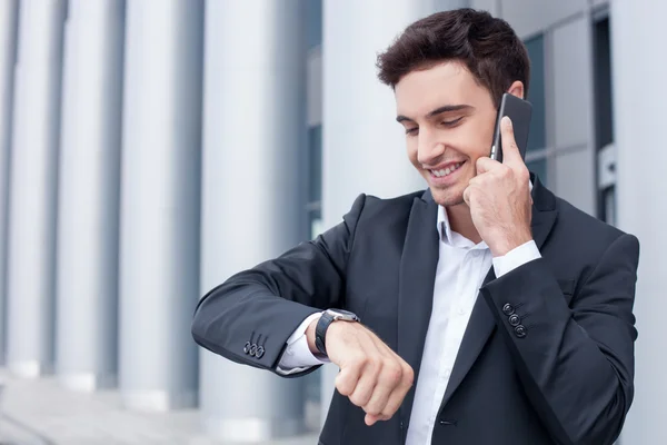 Cheerful young man is talking on the telephone