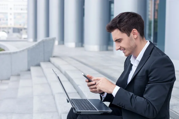 Attractive young businessman is using modern technology — Stock Photo, Image