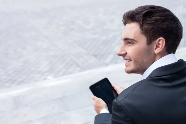 Jovem empresário atraente está usando tablet para o trabalho — Fotografia de Stock