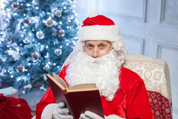 Old Father Christmas is relaxing in his chair — Stock Photo, Image