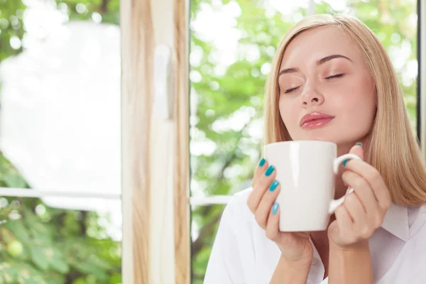 Attractive young woman is enjoying hot drink — 스톡 사진