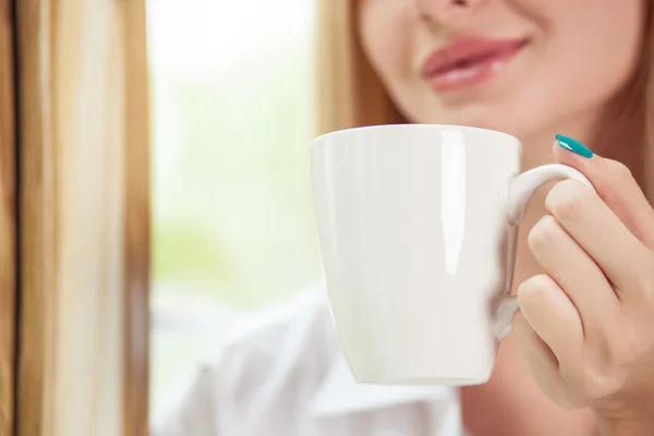 Cheerful young girl is drinking hot coffee — 스톡 사진