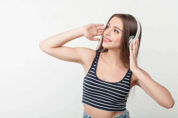 Beautiful young girl is enjoying song from headphones — Stock Fotó