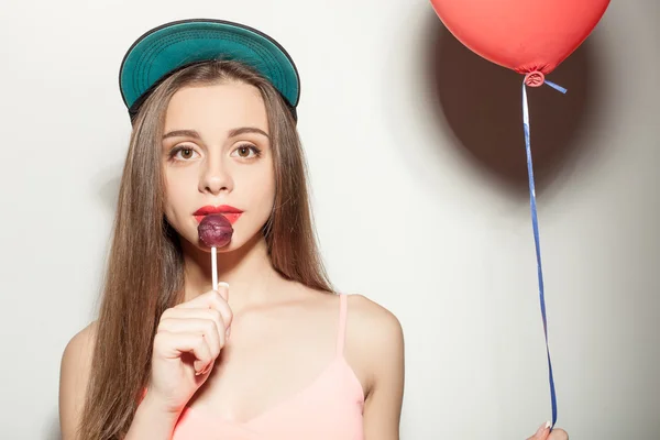 Cheerful young styled woman is enjoying sweet candy — Stock fotografie