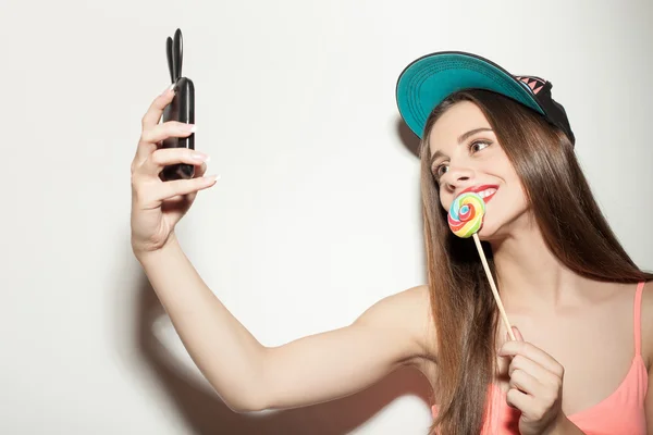 Attractive young hipster girl is photographing herself — Stock Photo, Image