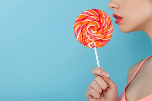 Attractive young woman is enjoying sweet candy — Zdjęcie stockowe