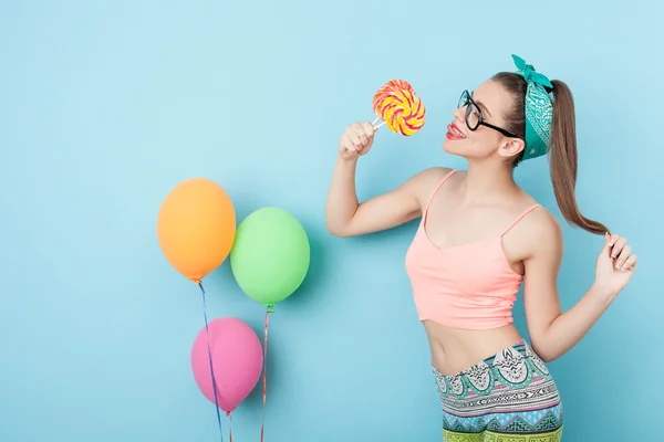 Alegre joven estilo mujer es comer caramelos — Foto de Stock