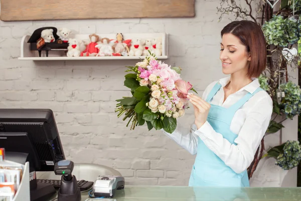 Приваблива молода продавчиня працює в квітковому магазині — стокове фото