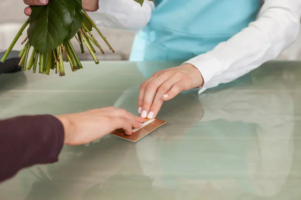 Skilled saleswoman is serving her client in flower shop — Stockfoto