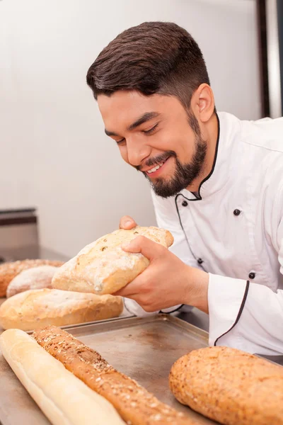Atractivo joven chef está trabajando con productos horneados — Foto de Stock