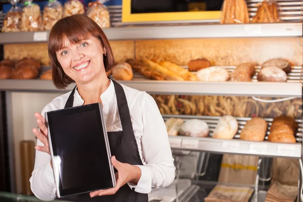Nydelig kjøkkensjef bruker moderne teknologi i bakeriet. – stockfoto