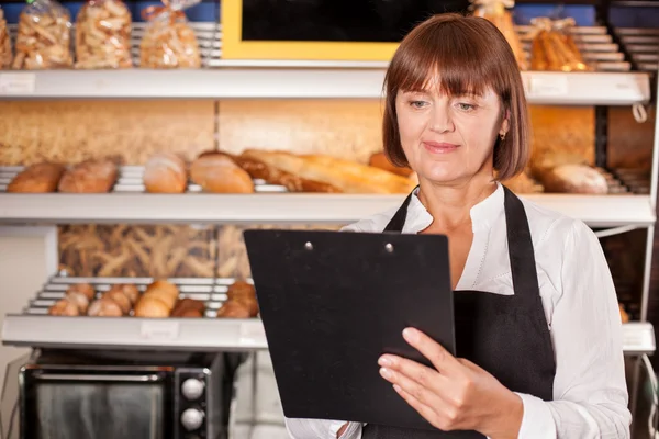 Beautiful female baker is preparing for her work — Stock Photo, Image