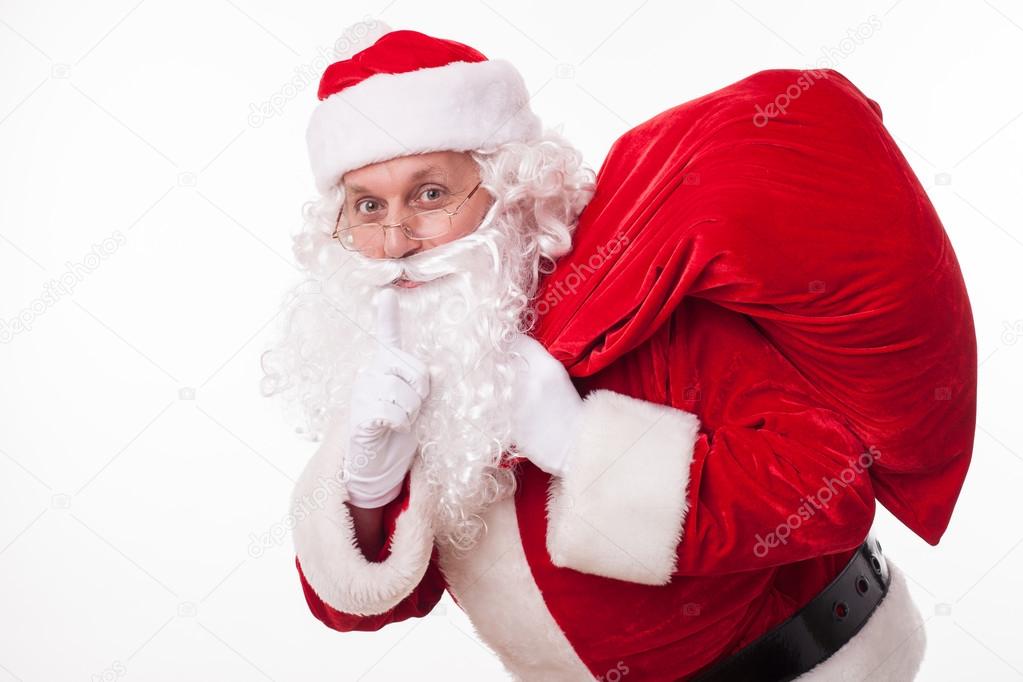 Cheerful Santa Claus is carrying presents secretly — Stock Photo